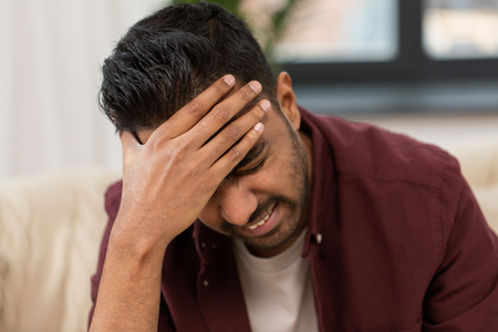 close up of man suffering from head ache at homeの写真素材