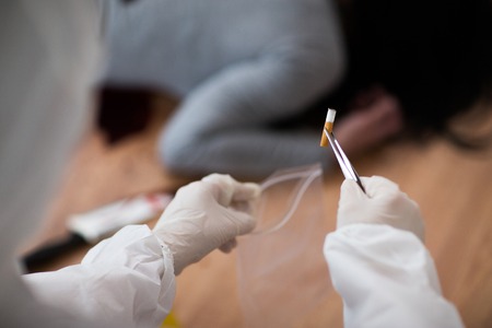 investigation, forensic examination and people concept - criminalist collecting evidence of murder...