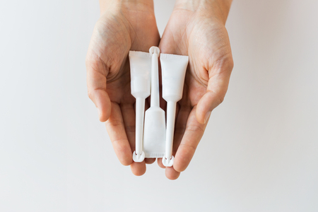 hand holding tubes of micro enemaの写真素材