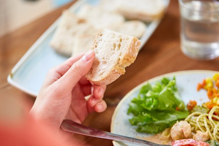 hand of woman holding piece of bread