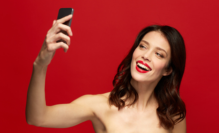 beautiful woman taking selfie with smartphoneの写真素材
