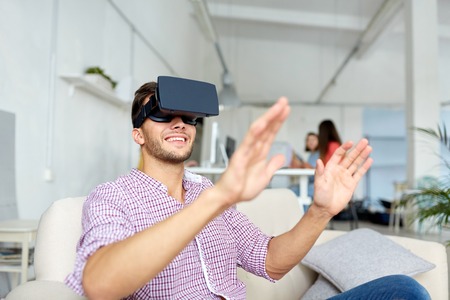 happy man with virtual reality headset at office