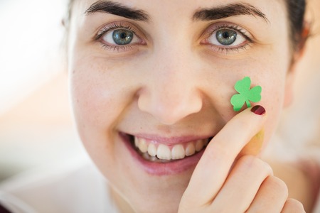 close up of happy young woman face with shamrockの写真素材