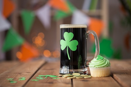 shamrock on glass of beer, green cupcake and coinsの写真素材