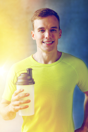 smiling man with protein shake bottleの写真素材
