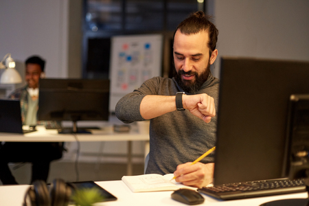 man with smartwatch using voice recorder at officeの写真素材