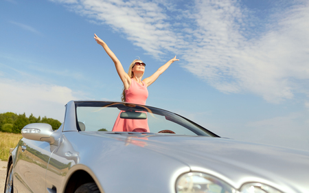 happy young woman in convertible carの写真素材