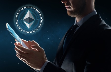 businessman with tablet pc and ethereum hologramの写真素材
