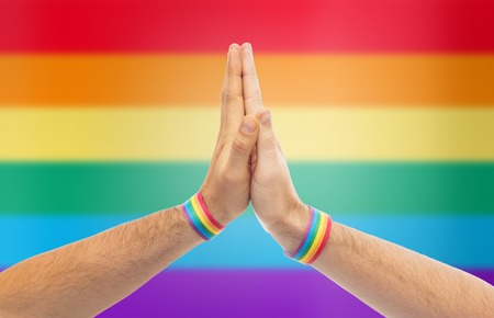hands with gay pride wristbands make high fiveの写真素材