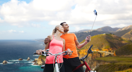 couple with bicycle and smartphone selfie stickの写真素材