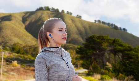 woman with earphones running over big sur hillsの写真素材