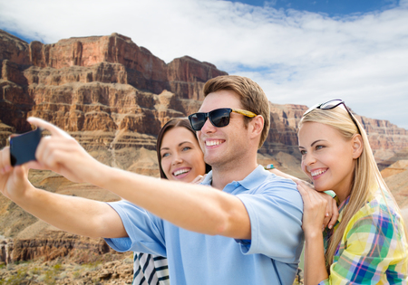 group of happy friends taking selfie by cell phoneの写真素材