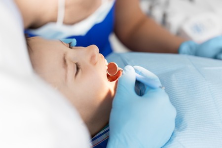 dentist checking for kid teeth at dental clinic