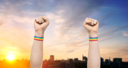 hands with gay pride rainbow wristbands shows fistの写真素材