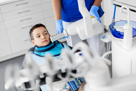 dentist making x-ray of kid teeth at dental clinicの写真素材