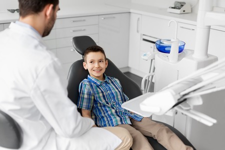 dentist talking to kid patient at dental clinicの写真素材