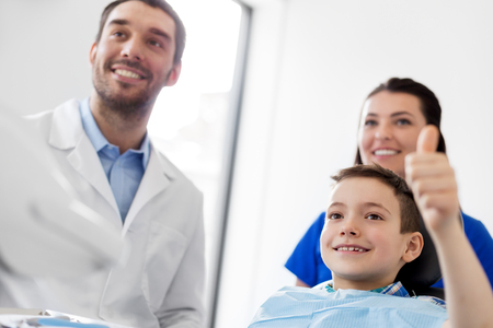 dentists and happy kid patient at dental clinicの写真素材