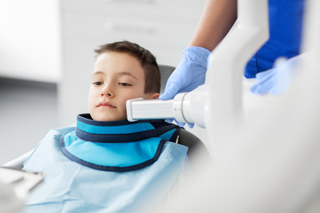 dentist making x-ray of kid teeth at dental clinicの写真素材