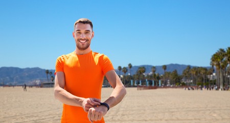 sport and healthy lifestyle concept - man with fitness tracker training outdoorsの写真素材