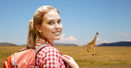 happy woman with backpack over african savannahの写真素材