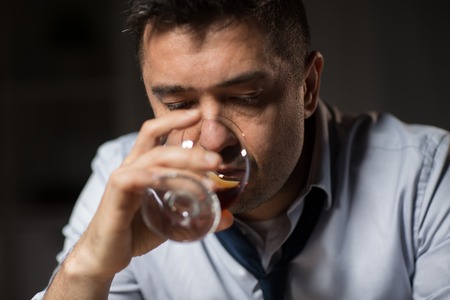 close up of drunk man drinking alcohol at nightの写真素材