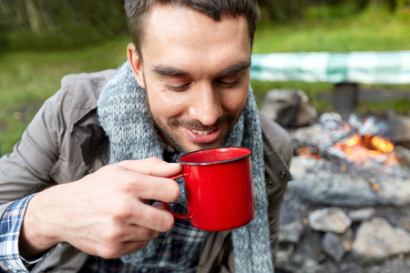 close up of smiling man drinking from cup at campの写真素材