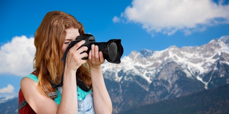 woman with backpack and camera over alps mountains