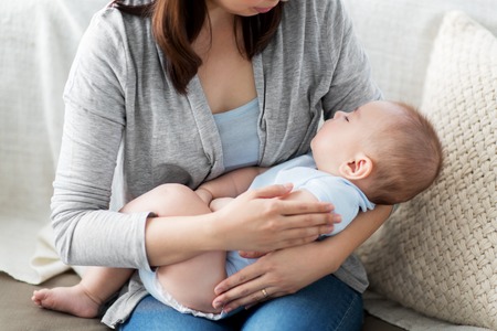 close up of mother holding sleeping asian baby boy