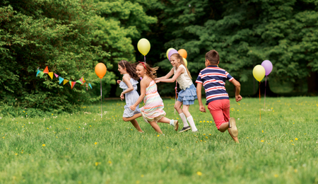 happy kids playing tag game at birthday partyの写真素材
