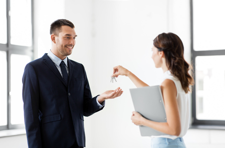 realtor giving key to customer at new officeの写真素材