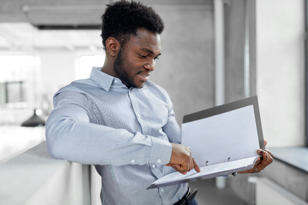 african american businessman with folder at officeの写真素材