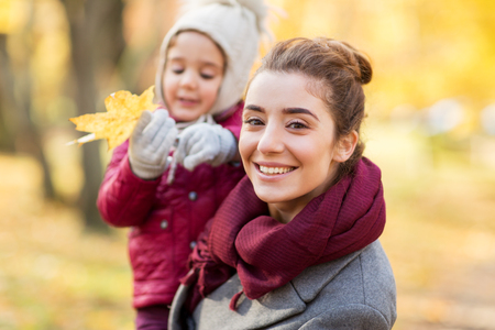 happy mother with little daughter at autumn parkの写真素材