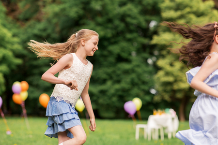 happy girls playing tag game at birthday partyの写真素材