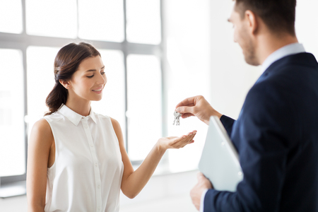 realtor giving key to customer at new officeの写真素材