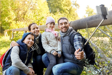 family taking photo by selfie stick outdoorsの写真素材