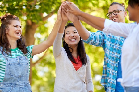 happy friends making high five in park