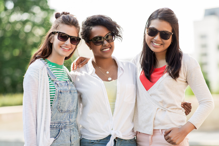 happy young women in sunglasses outdoorsの写真素材