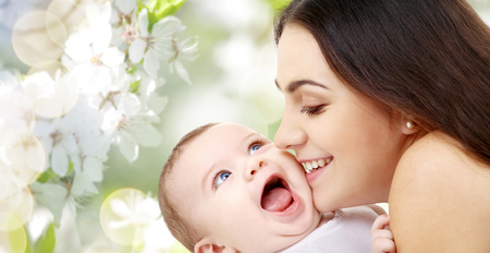 mother with baby over cherry blossom backgroundの写真素材