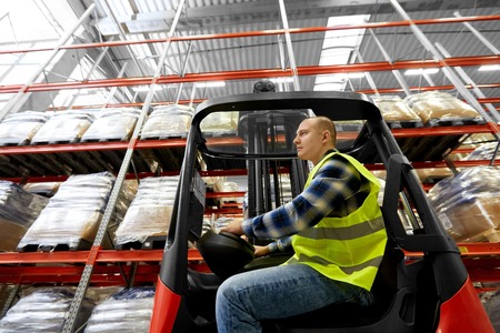 male worker driving forklift loader at warehouse