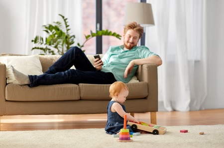 father and baby playing with toy blocks at homeの写真素材