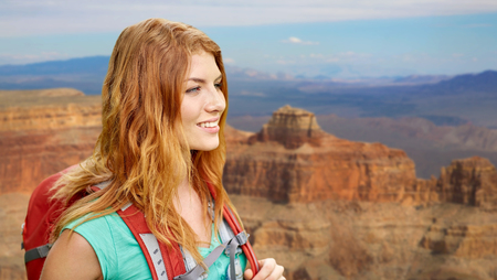 smiling woman with backpack over grand canyonの写真素材