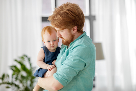 happy father with little baby daughter at homeの写真素材