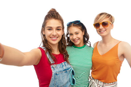 happy female friends in sunglasses taking selfieの写真素材