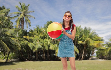 smiling teenage girl in sunglasses with beach ball