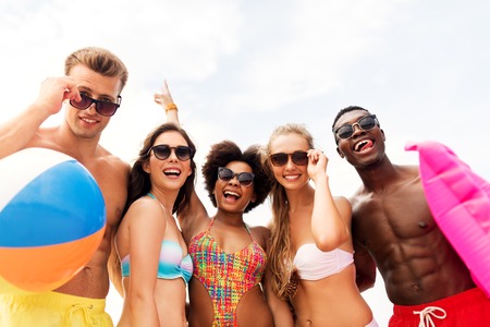 happy friends in sunglasses on summer beachの写真素材