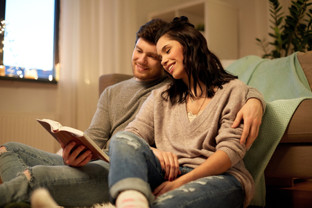 happy couple reading book at homeの写真素材