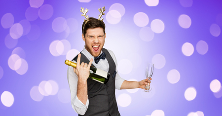 man with bottle of champagne at christmas partyの写真素材