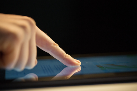 close up of hand using computer touch screenの写真素材