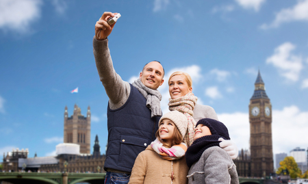 family taking selfie by camera over london cityの写真素材