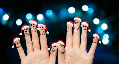 close up of ten fingers in santa hats over lightsの写真素材
